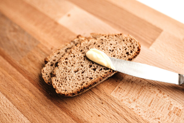 Slices of rye bread with butter on a wooden board